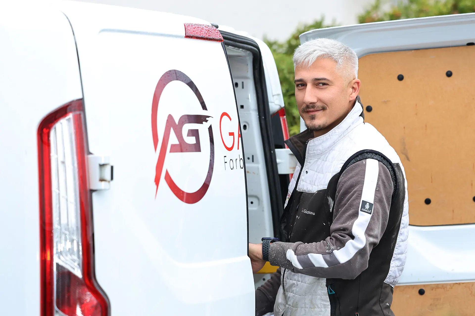 Malermeister Andrei Galatanu an der offenen Hecktür des GALATANU Firmenwagens in Wurmlingen